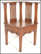 A late 19th Century  early 20th Century oak Arts and Crafts corner chair, pierced splat backs with