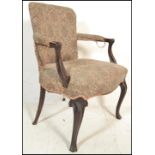 A 19th century French empire mahogany fauteuil armchair being raised on cabriole legs with a