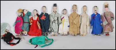 A collection of Chinese early 20th Century export ware ceramic and composite costume dolls all being