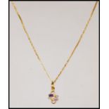 A stamped 916 22ct gold pendant necklace having a fine link chain having a pendant set with two