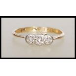 A stamped 9ct gold and platinum Art Deco ring having a platinum head set with three white stones.