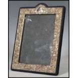 A continental silver easel back picture / photo frame having embossed Rococo influence scrolls and