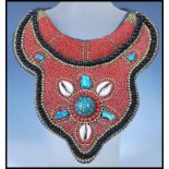 A 20th Century Tibetan tribal collar necklace constructed from a fabric panel stitched with red