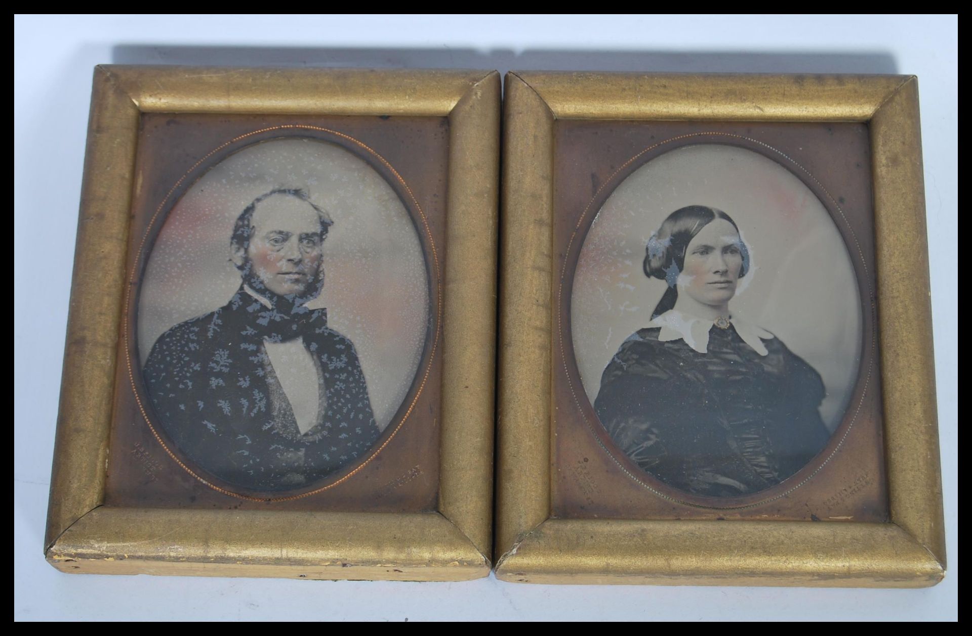 A pair of 19th Century Victorian wet plate photographs of a man and wife set within gilt frames with