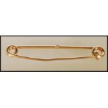 A 20th Century stamped 18ct gold safety pin brooch. Weight 7.5g. Measures approx 5cm wide.