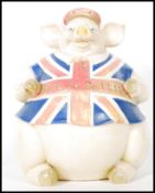 A contemporary large resin figure of a seated pig wearing a hat and Union Jack T-shirt with 'Best of