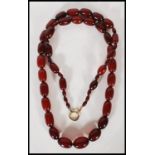 An early 20th Century circa 1930s simulated cherry amber graduating beaded necklace with gilt