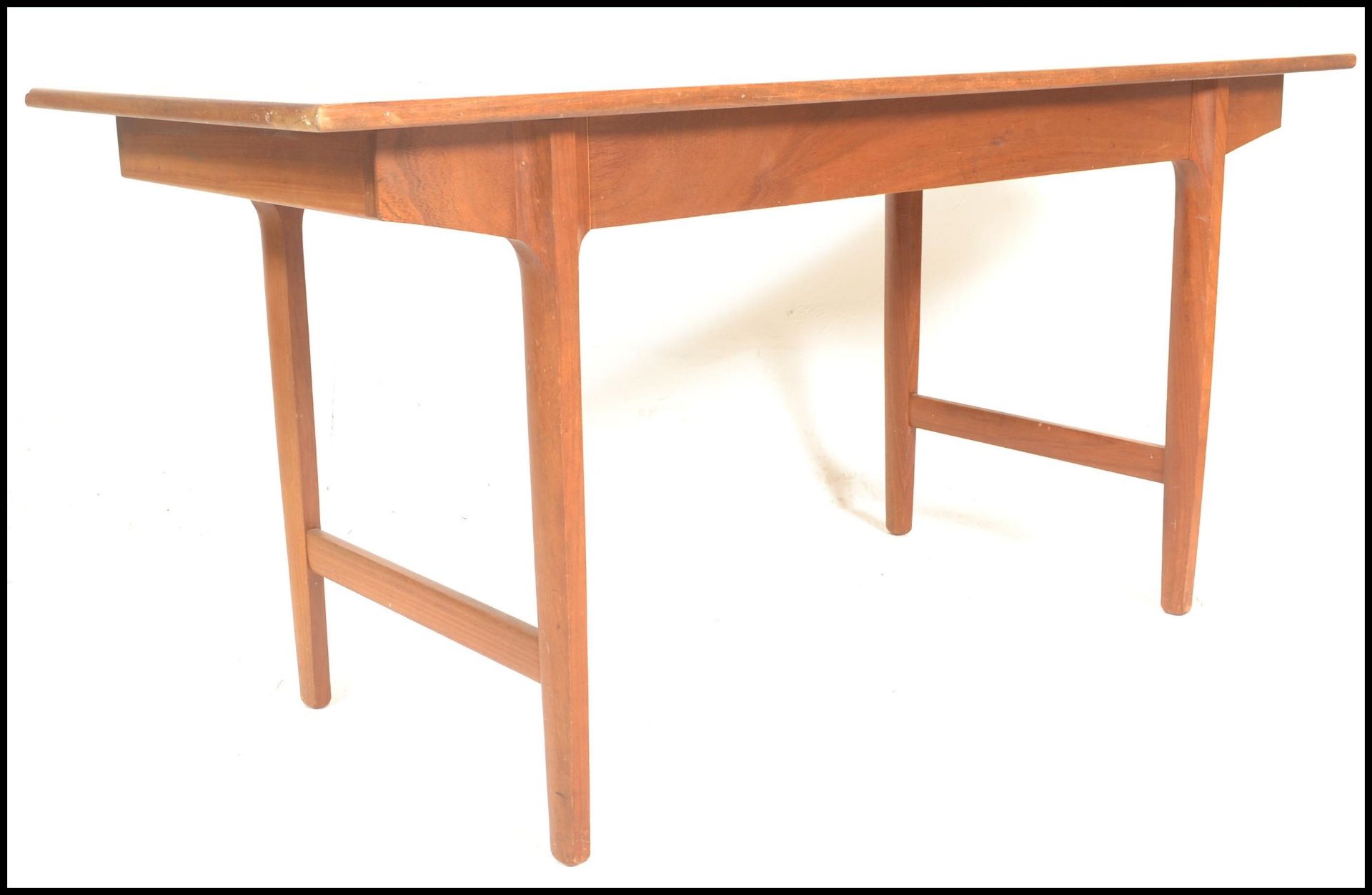 A mid century Bath Cabinet Makers teak wood Danish inspired dining table being raised on turned,