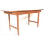 A mid century Bath Cabinet Makers teak wood Danish inspired dining table being raised on turned,