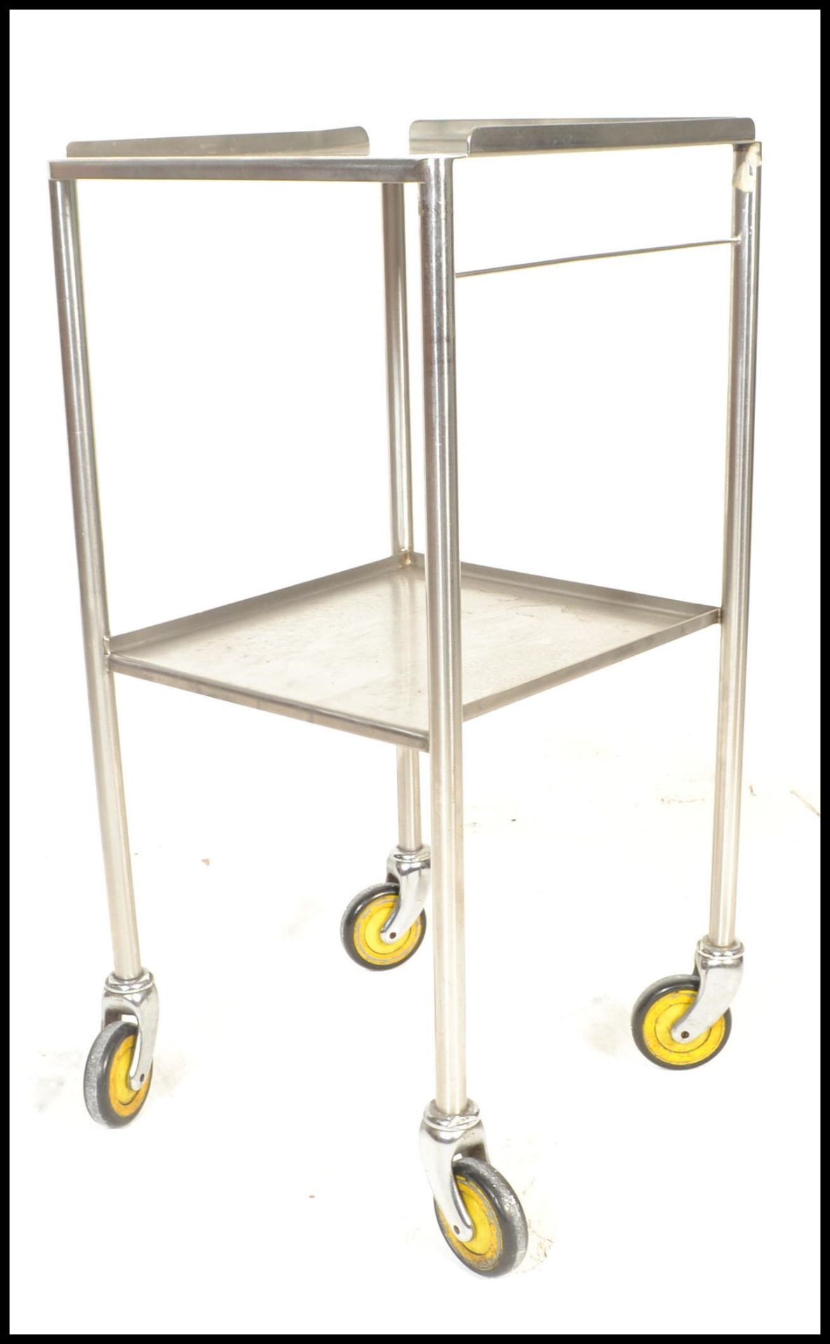 A vintage 20th Century chrome medical trolley having two tiers raised on round tubular supports with