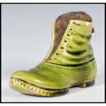 A 19th Century Victorian ceramic pin cushion in the form of boot having a green glaze with a straw