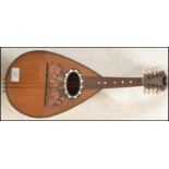An early 20th Century antique eight string mandolin having a tear drop shaped body with mother of