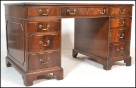 An antique style mahogany and tooled leather twin pedestal writing desk. Raised on bracket feet with