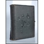 A 19th Century Victorian leather bound embossed photograph album with brass clasp containing several