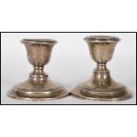 A near pair of silver hallmarked stub filled candlesticks, raised on circular bases, assay marks for