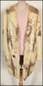A mid 20th Century white and brown rabbit fur coat having a red silk lining.