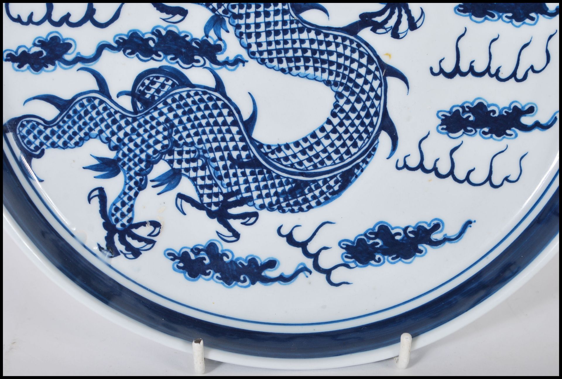 A 19th Century Chinese ceramic plate being hand painted in blue depicting a five toed dragon to - Bild 4 aus 6