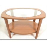 A vintage 20th century teak wood G-Plan style Astral coffee table of oval form with inset glass