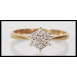 A stamped 9ct gold ring having a flower head cluster of round cut diamonds. Diamonds estimated at