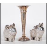 A pair of 20th Century Chinese cruets in the form of stylised cats having repousse floral sprays