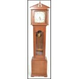 A contemporary mahogany long case grandfather clock, the clock with arch breakfront pediment over