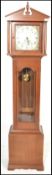 A contemporary mahogany long case grandfather clock, the clock with arch breakfront pediment over