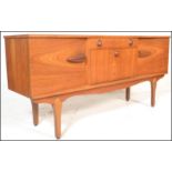 A vintage mid 20th century teak wood sideboard having a central drop down bar compartment with