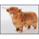 A Beswick ceramic figurine of a Highland cattle bull being stamped for Beswick, England to the foot.