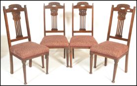 A set of four early 20th Century Arts and Crafts oak dining chairs, gcarved backrests with
