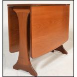 A 1970's teak wood Danish influenced G-Plan drop leaf dining table raised on shaped supports with