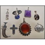 A selection of silver pendants to include an elephant pendant set with a lapis lazuli bead, a