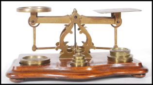 A set of late 19th / early 20th Century brass postal scales, with a selection of weights  within a