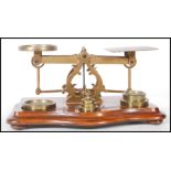 A set of late 19th / early 20th Century brass postal scales, with a selection of weights  within a