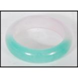 A vintage Chinese jade bracelet bangle, the two tone bangle of circular form. Measuring 6cm diameter