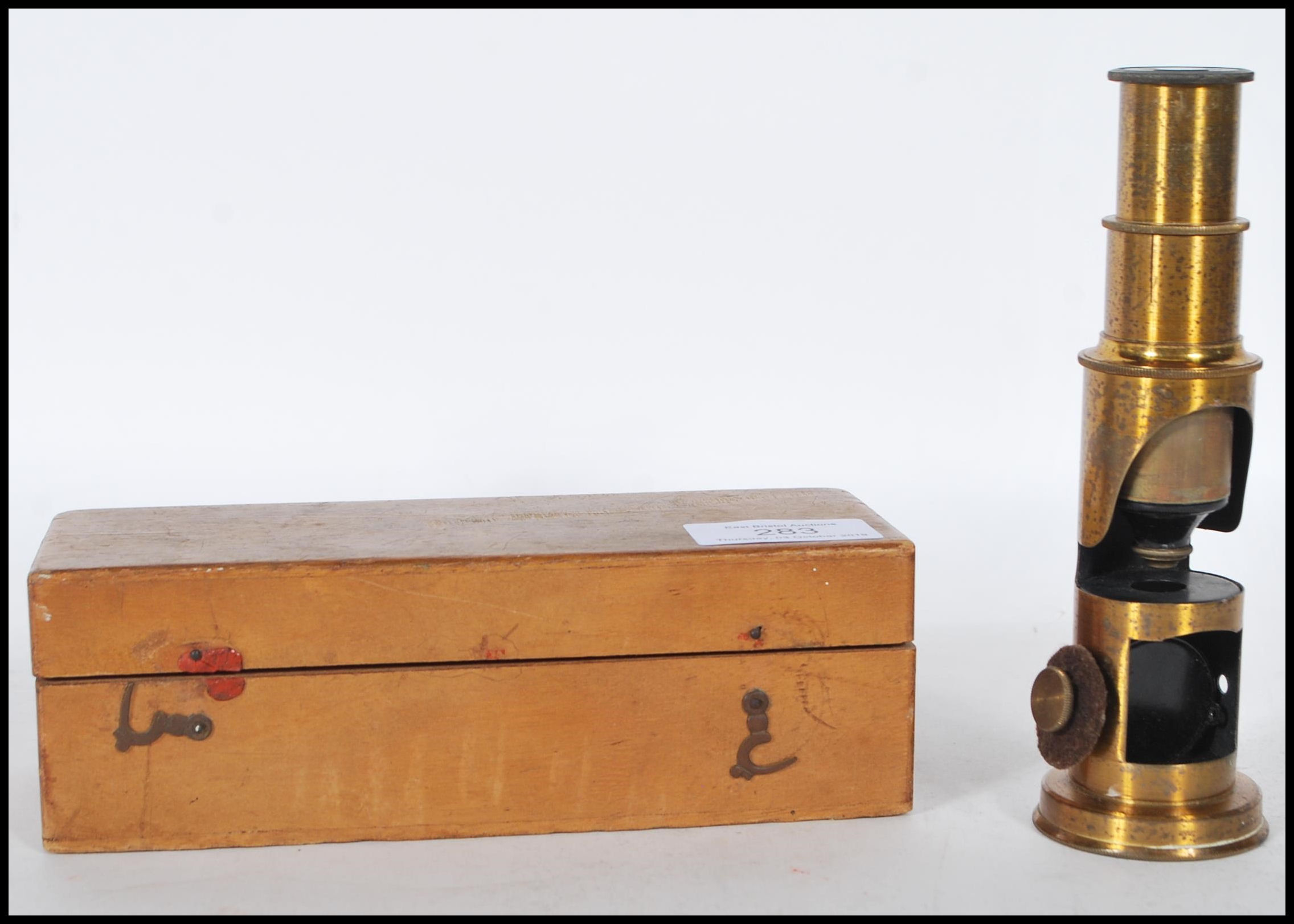 A late 19th Century brass students pocket cased microscope, adjuster to side fitted in a hinged