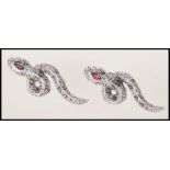 A pair of silver and marcasite set earrings in the form of snakes. Each one set with a single