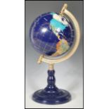 A vintage 20th century lapis lazuli desk top globe having precious stone inlay raised on a