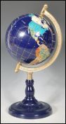 A vintage 20th century lapis lazuli desk top globe having precious stone inlay raised on a