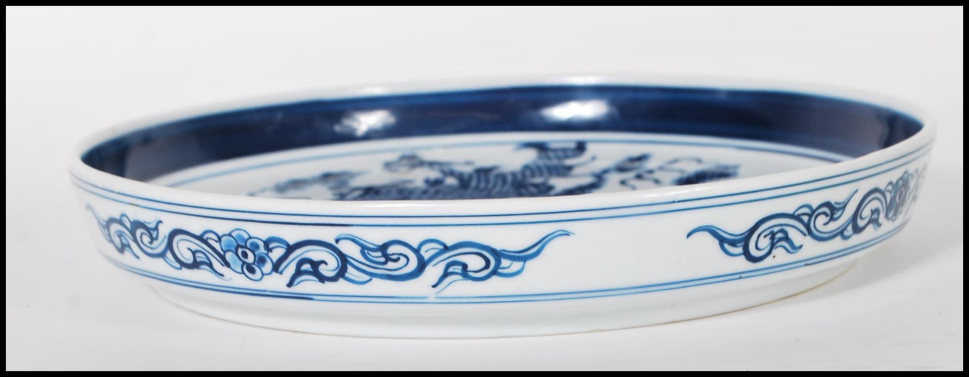 A 19th Century Chinese ceramic plate being hand painted in blue depicting a five toed dragon to - Bild 6 aus 6