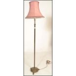 A 20th Century Corinthian column standard lamp raised on a circular base cast in relief with