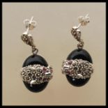 A pair of Cartier style silver and onyx drop earrings in the form of panthers having marcasite