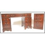 A reproduction Georgian style mahogany veneered kneehole twin pedestal writing desk with tooled