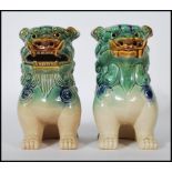 A pair of mid 20th Century Chinese porcelain temple lions / dogs of  Fu. Both modeled with a jade