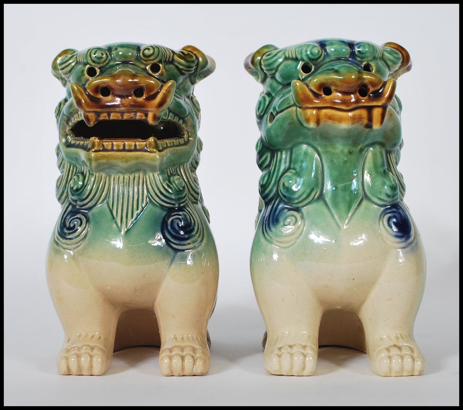 A pair of mid 20th Century Chinese porcelain temple lions / dogs of  Fu. Both modeled with a jade