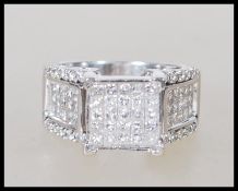 A stamped 14ct white gold and diamond ring. The he