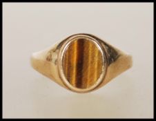 A 9ct gold ring set with an oval tigers eye panel