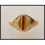 A 9ct gold ring set with an oval tigers eye panel