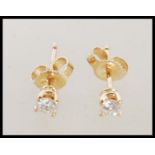 A pair of 14ct gold diamond solitaire earrings set