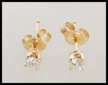 A pair of 14ct gold diamond solitaire earrings set