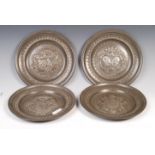 SET OF FOUR ANTIQUE PEWTER REPOUSSE CRESTED PLATES.